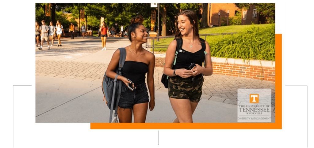 Two students smiling at each other while walking on campus.